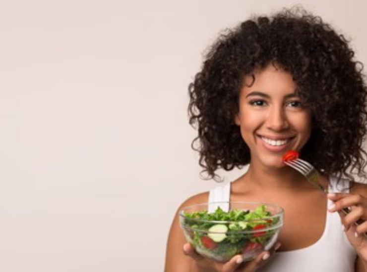 Una giovane donna mangia insalata