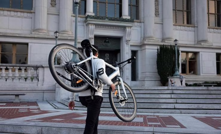 ragazzo trasporta bicicletta elettrica 