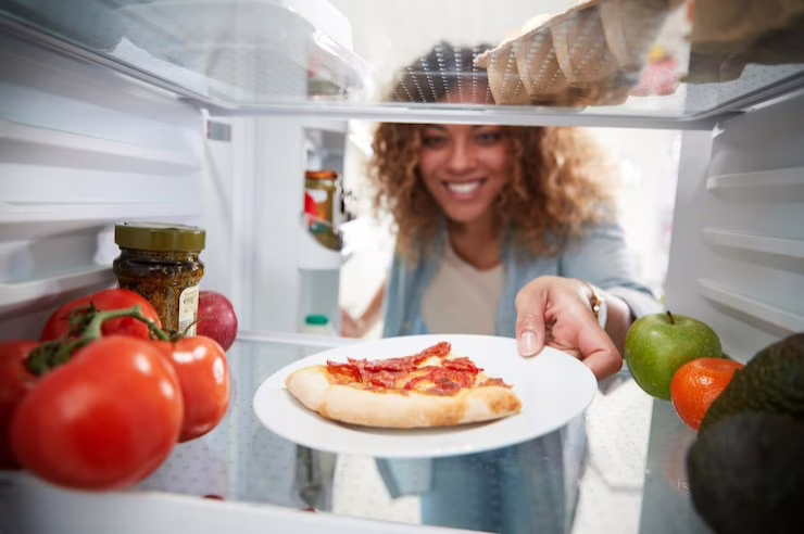 Persona che mette cibo in frigo