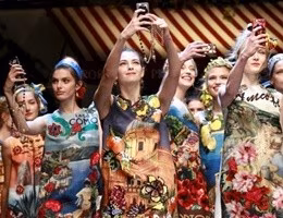 Models take selfie with mobile phones during the parade at the end of the Dolce & Gabbana Spring/Summer 2016 collection during Milan Fashion Week