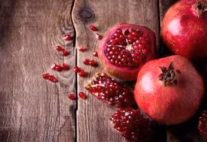 Some red pomegranates on old wooden table