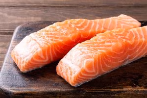 Fresh raw salmon fillet. Old wooden background. Banner selective focus.