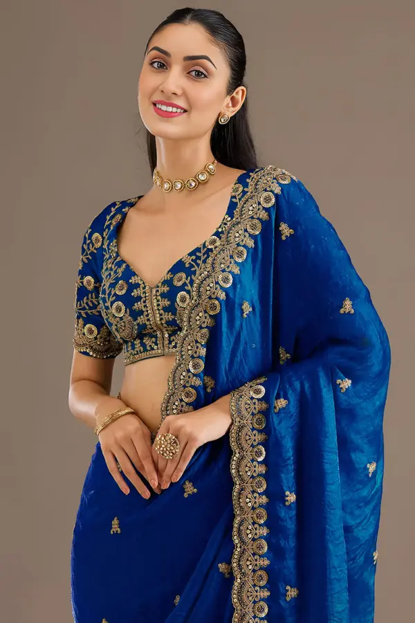 Close up of sequins, zari, diamond and pearl work on royal blue saree
