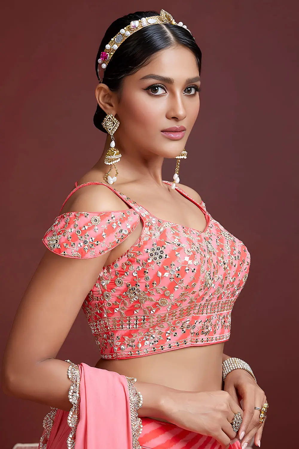 Swarovski crystals and heavy embroidery detail on peach silk lehenga
