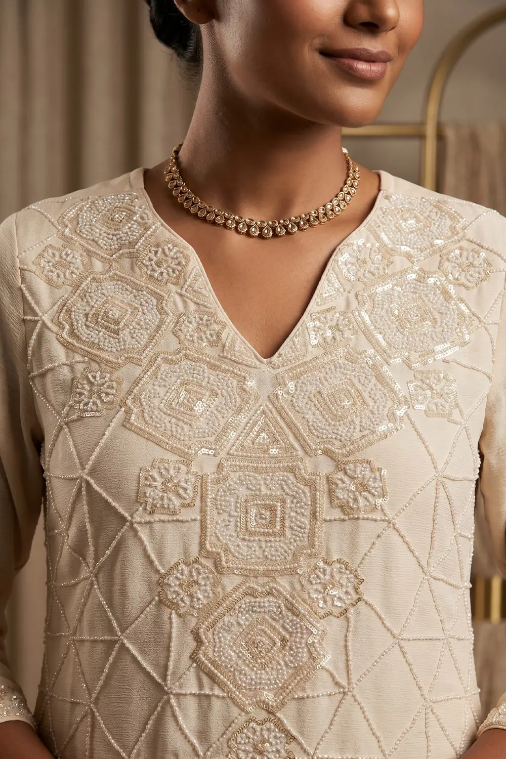 Close up of beaded ivory chinon kurta top with tassel detail