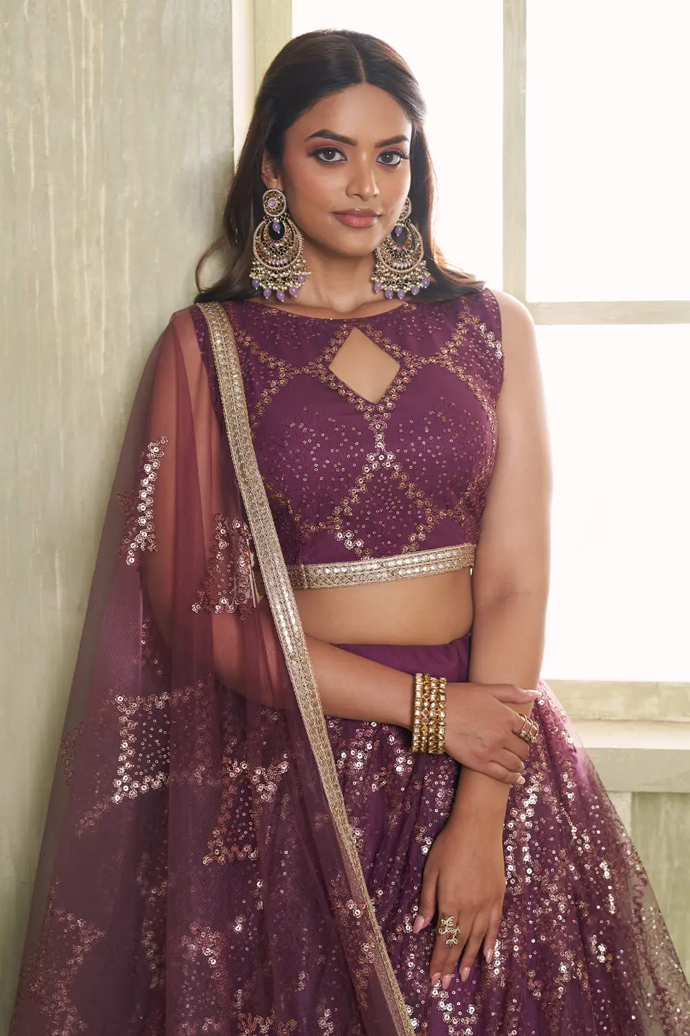 Close up of tone-to-tone thread work and glitter sequins on wine net lehenga