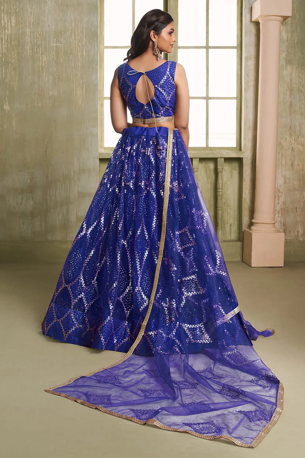 Close up of tone-to-tone thread work and glitter sequins on blue net lehenga