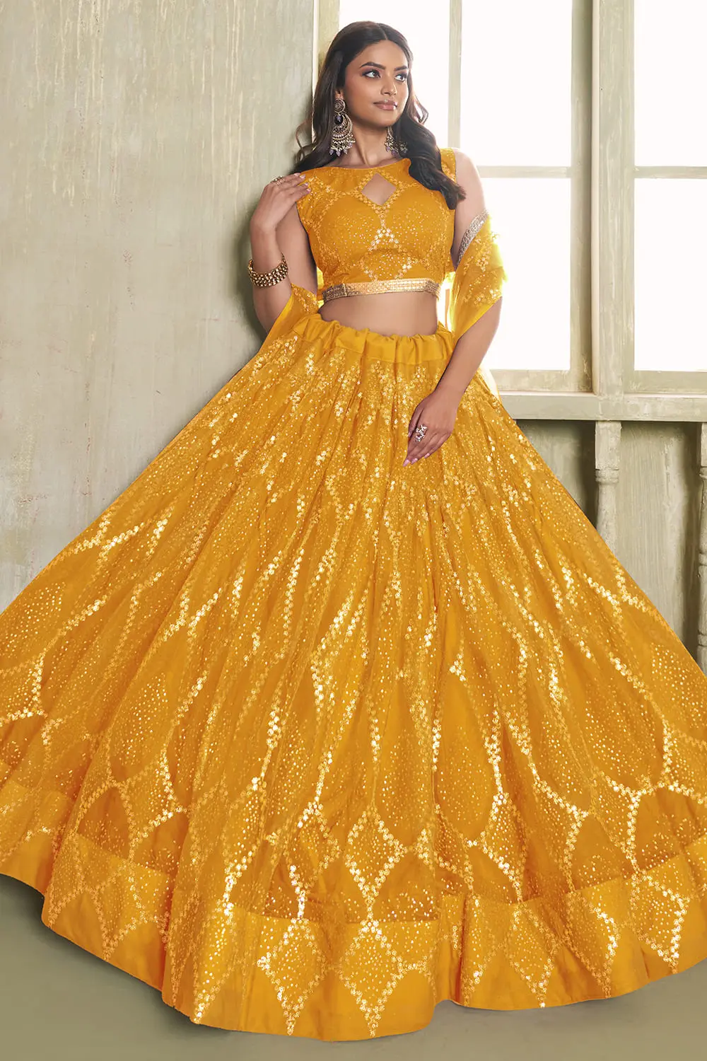 Yellow butterfly net lehenga with fancy lace finish seated view