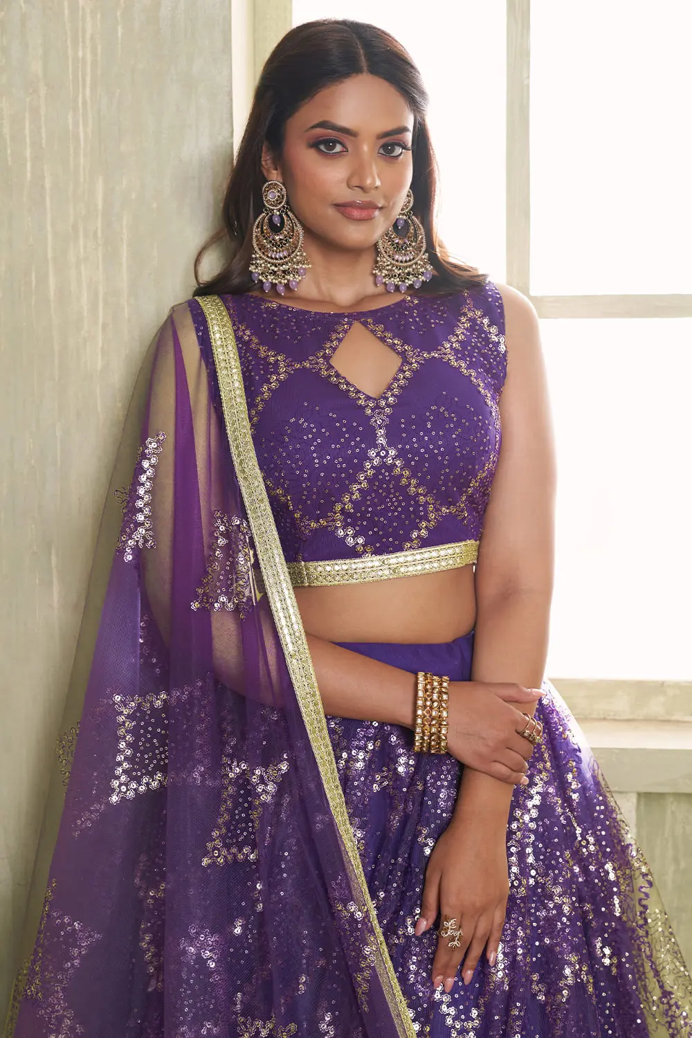 Close up of tone-to-tone thread work and glitter sequins on deep purple net lehenga