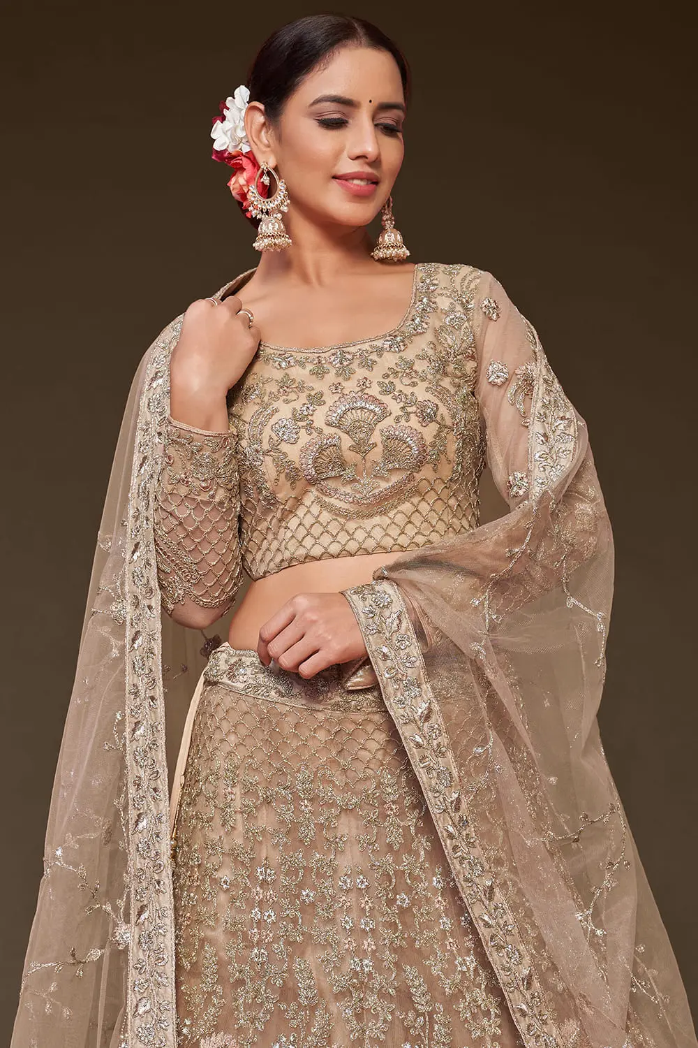 Gold soft net lehenga styled with embroidered blouse and dupatta