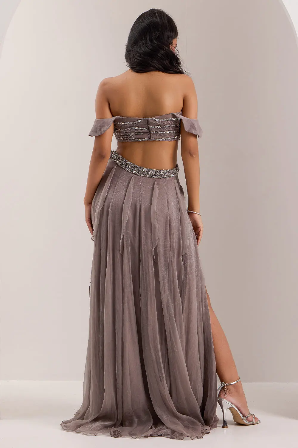 Back view of grey off shoulder blouse and frill slit skirt set