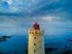 yellow and red lighthouse near body of water at daytime