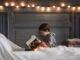 boy reading book on bed