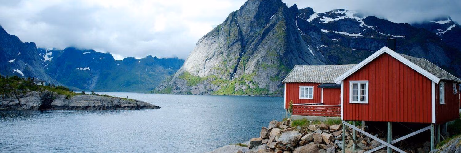 red and white wooden house in front of body of water