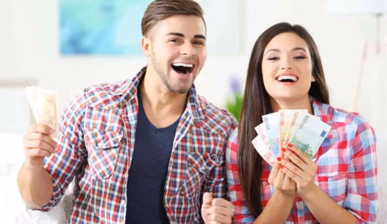 Coppia felice con soldi (Depositphotos foto) - www.frasidadedicare.it