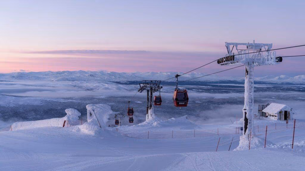 a ski lift going over a snow covered mountain