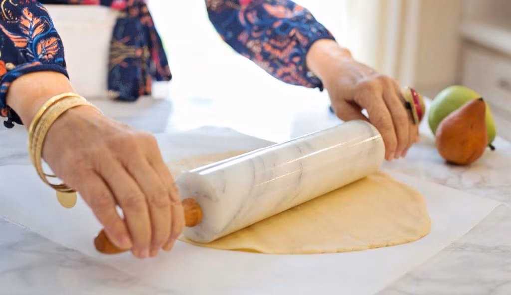 Stendere la pasta con mattarello su carta forno