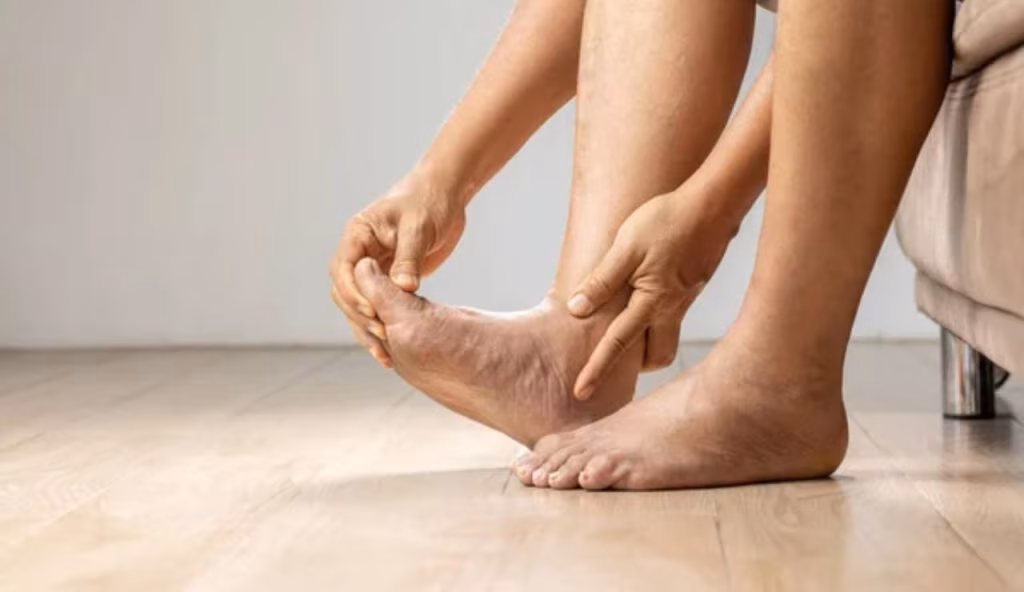 Una persona mentre massaggia i piedi (Depositphotos)