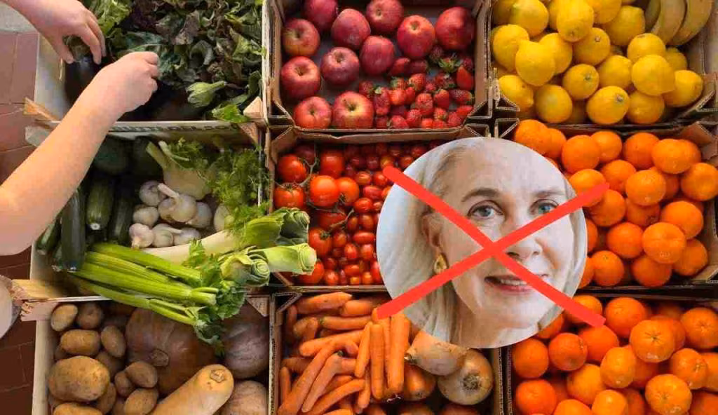 Donna con i capelli bianchi con casse di frutta e verdura