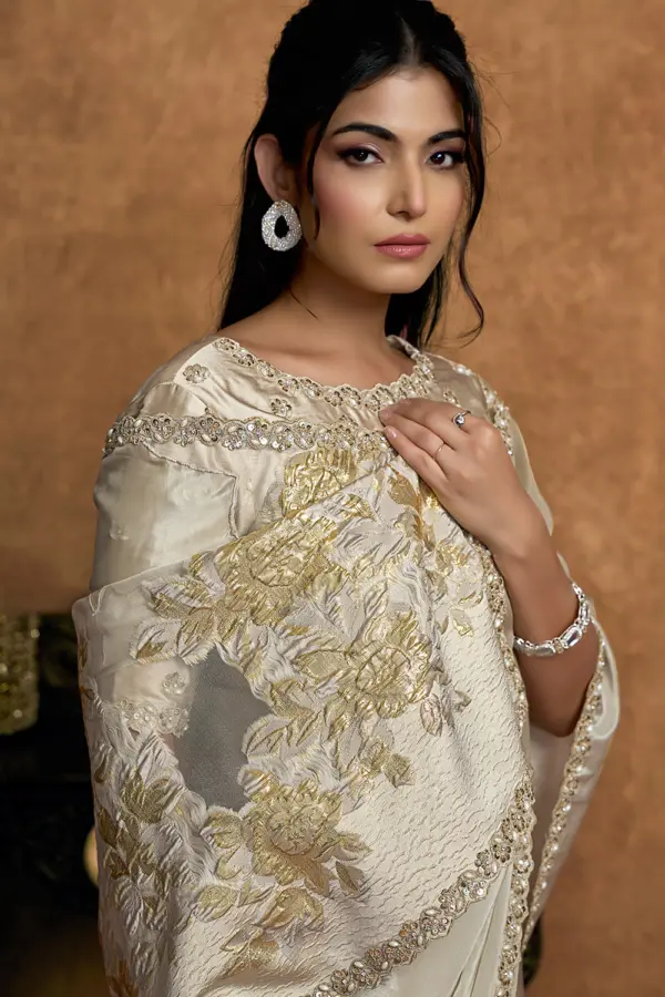 Close-up of intricate pearl and sequin work on ivory saree