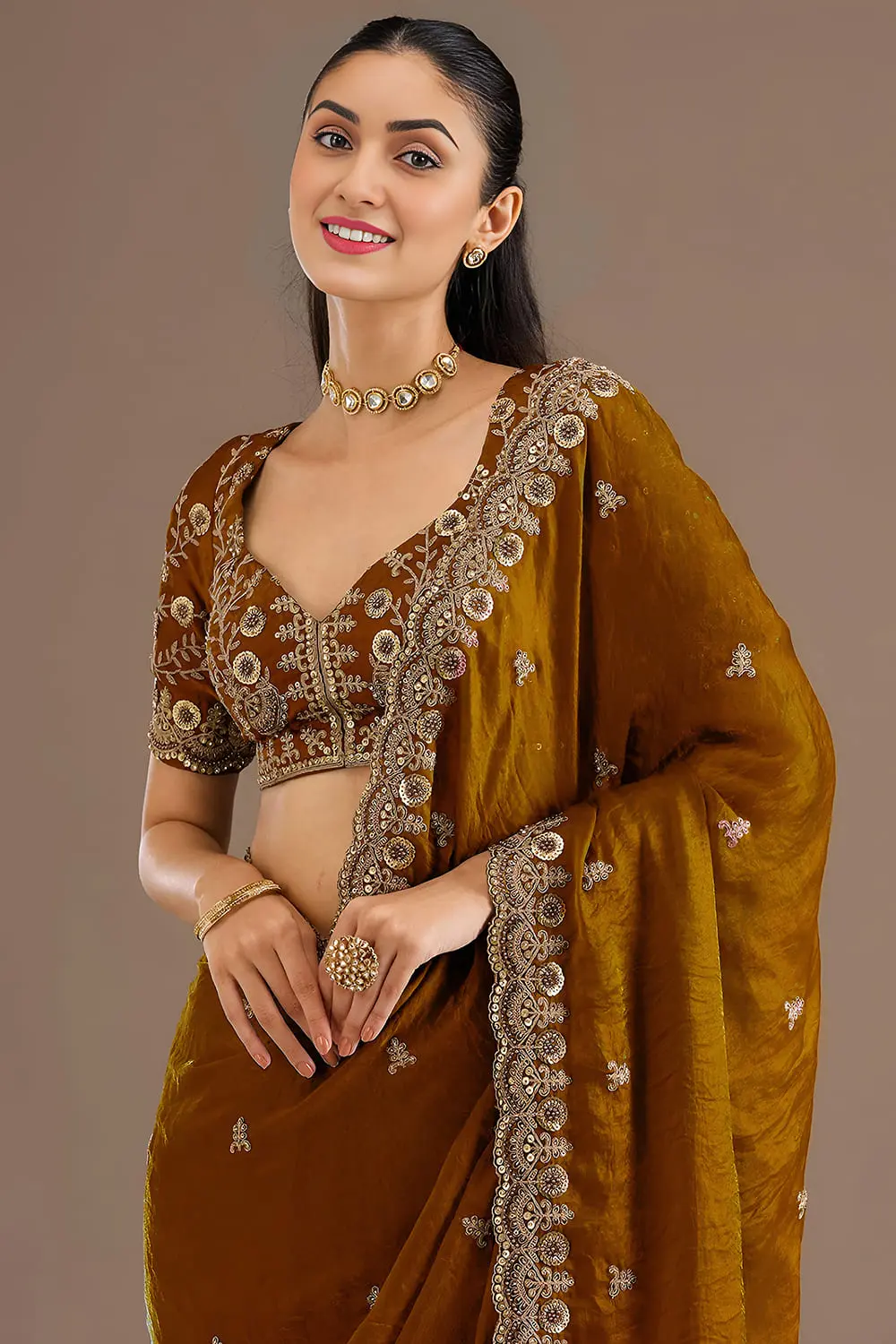 Close up of sequins, zari, diamond and pearl work on gold saree