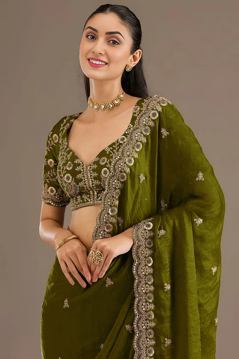 Close up of sequins, zari, diamond and pearl work on olive green saree