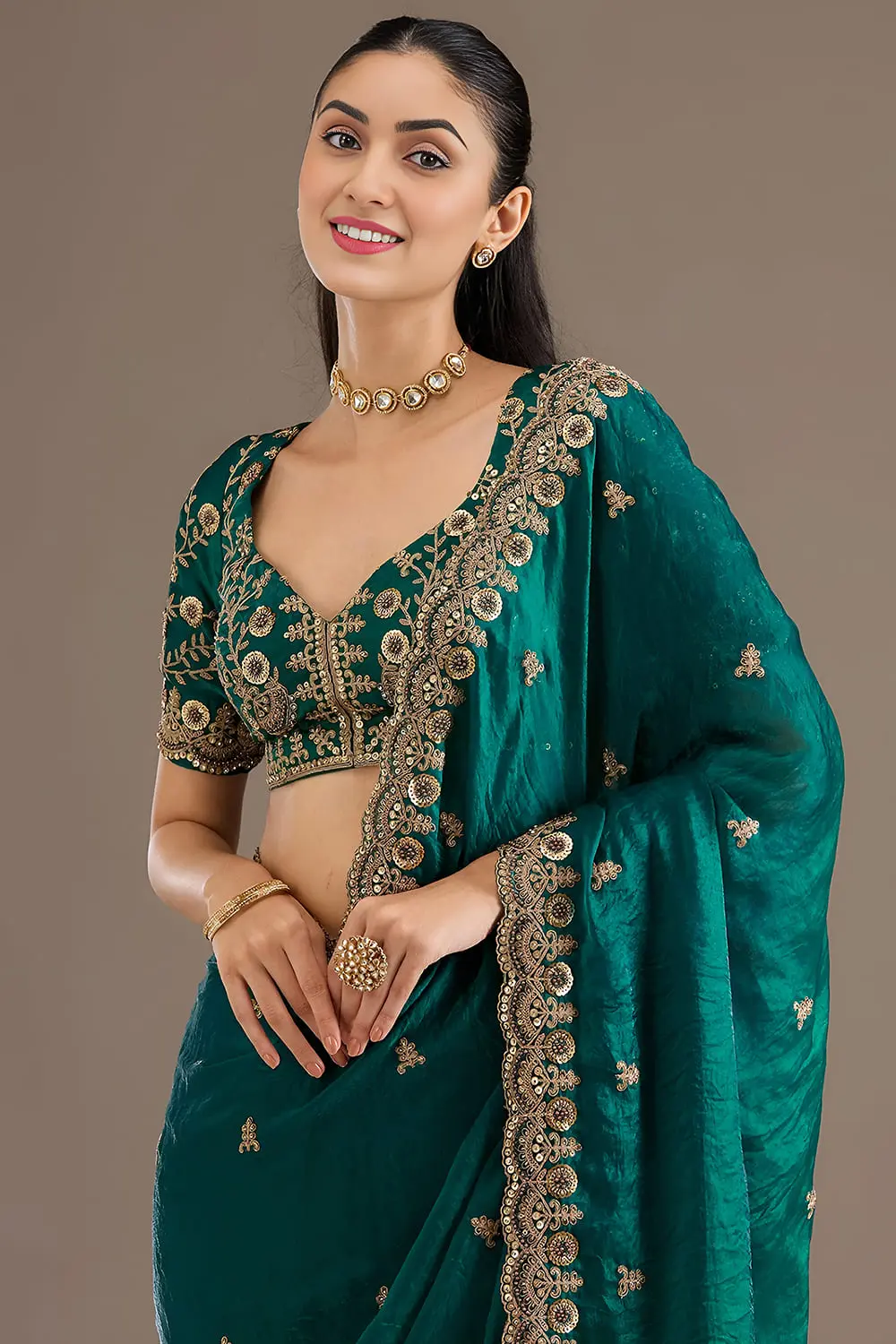 Close up of sequins, zari, diamond and pearl work on rama green saree