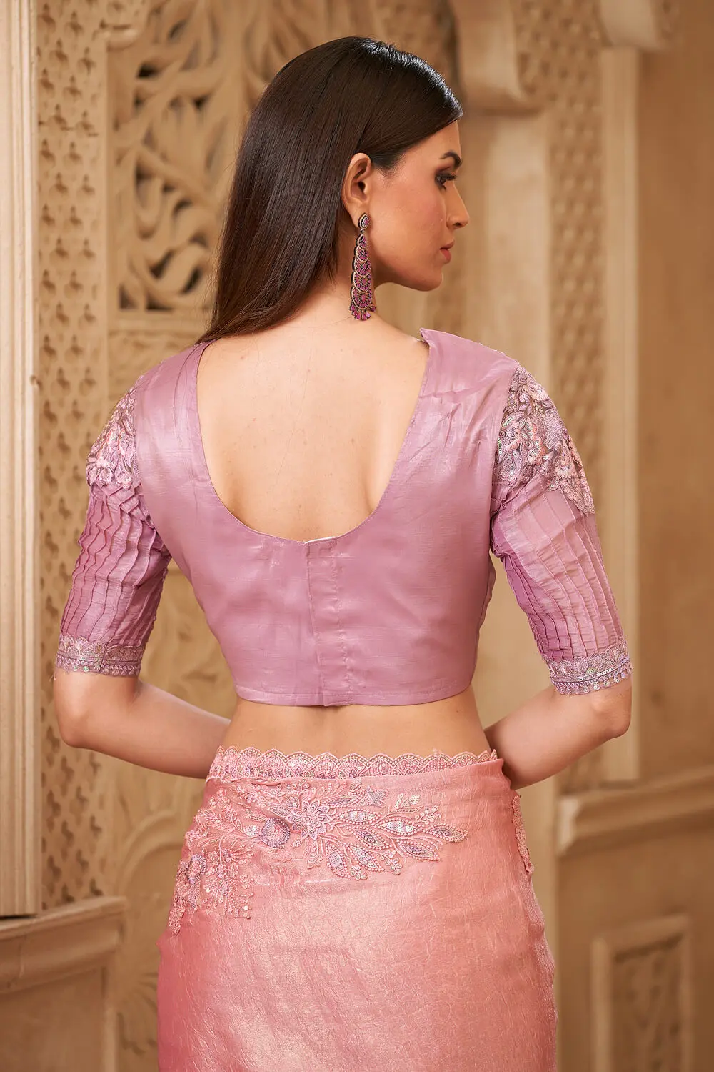 Embroidery work and tassel lace detail on pink georgette saree