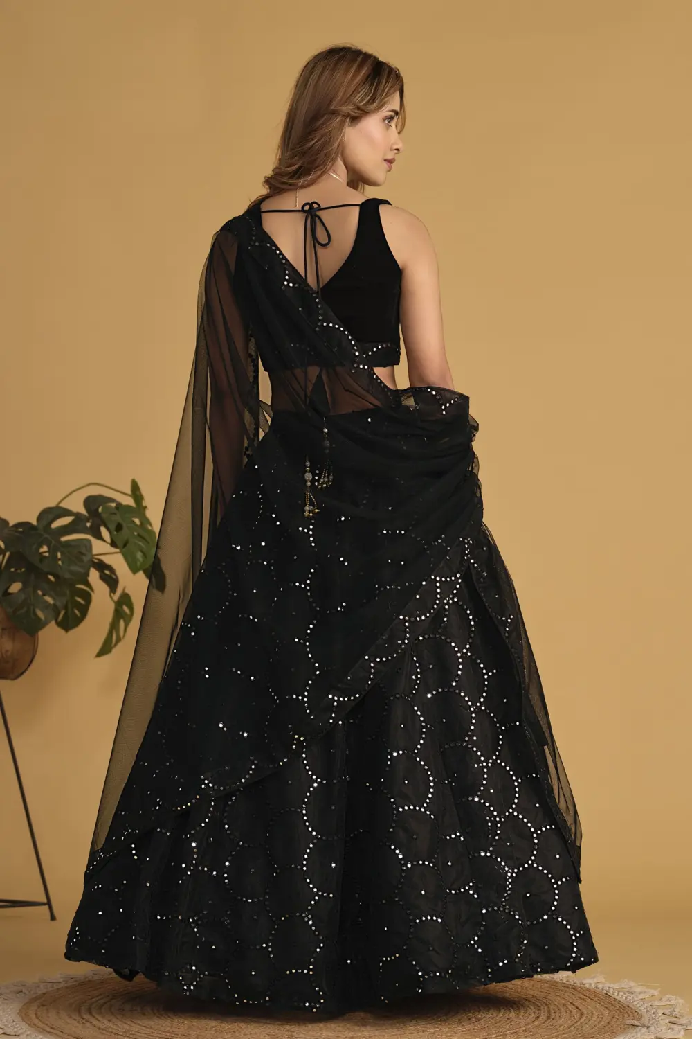 Back view of black velvet lehenga with georgette skirt and net dupatta