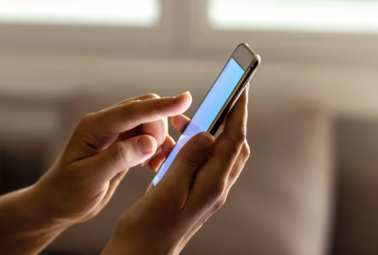 Illustrazione di un telefono in mano (Canva FOTO) - systemscue.it